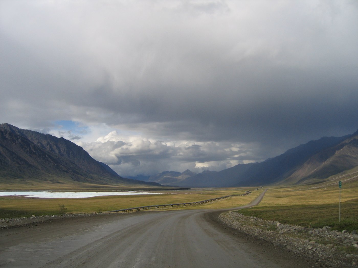 The gravel James Dalton Highway running north across the Alaska landscape